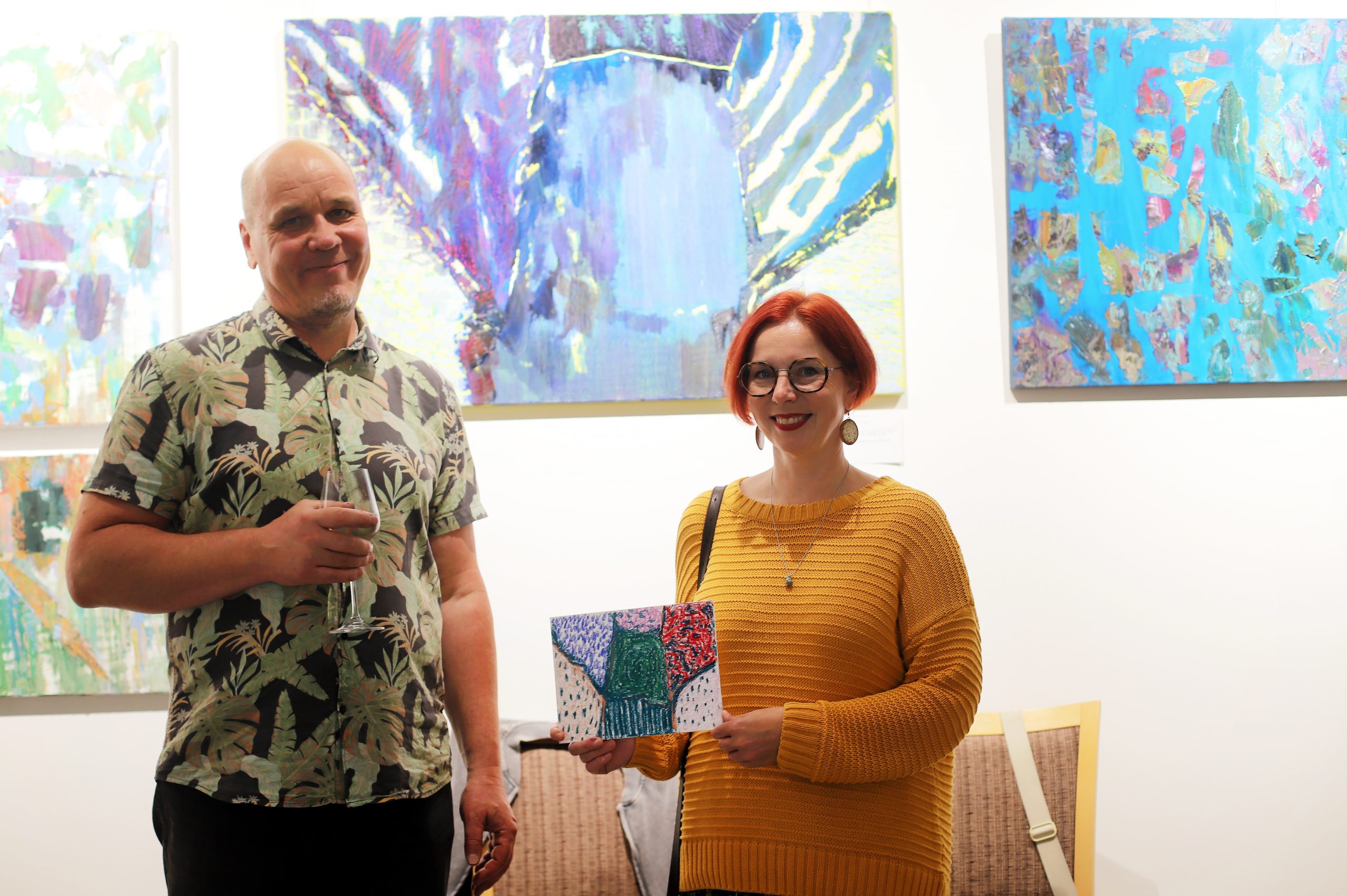 A participant shows her finished drawing beside the artist